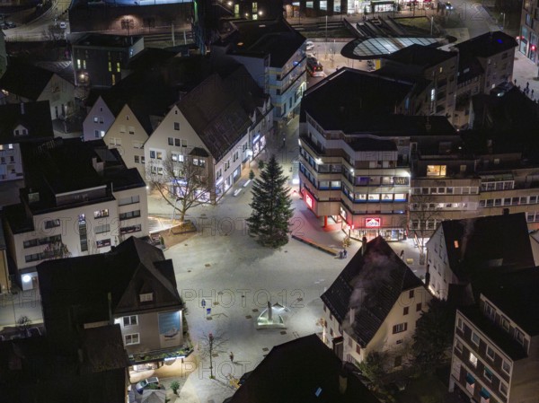 Night view of an urban square with illuminated buildings and a large tree, Nagold, Calw district,