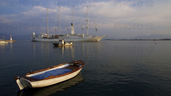 Nauplion harbour, sailing ship and small boat in harbour at sunset in calm water, Nauplion,