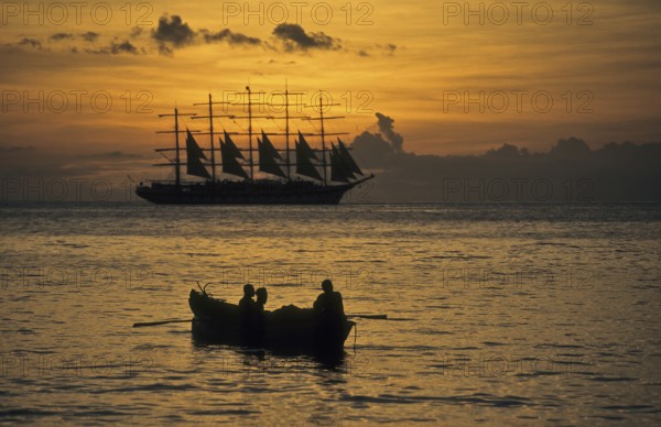 Romantic view of the Caribbean Sea during sunset In the foreground small fishing boat with three