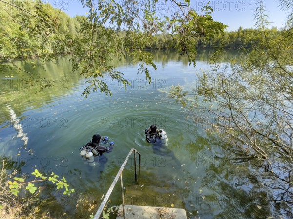 Recreational divers with diving equipment Diving tanks swim near the shore on the water surface of