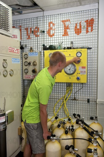 Dive instructor operates compressor fills scuba tanks scuba diving equipment for recreational