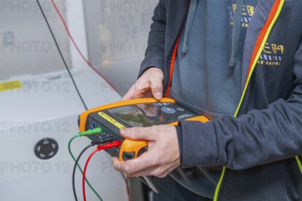 Technician carries out diagnostics for solar system with measuring device device