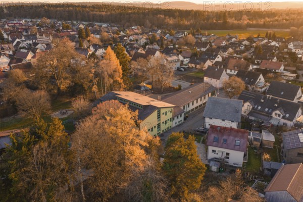 Rural area with houses and autumn trees in a warm evening atmosphere, Althengstett, Calw district,