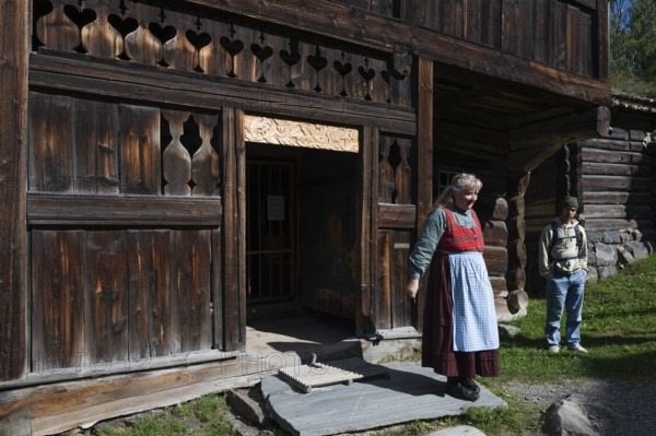 Tourist guide in traditional traditional costume and visitor, BjÃ¸rnstad, farm from VÃ¥gÃ¥,