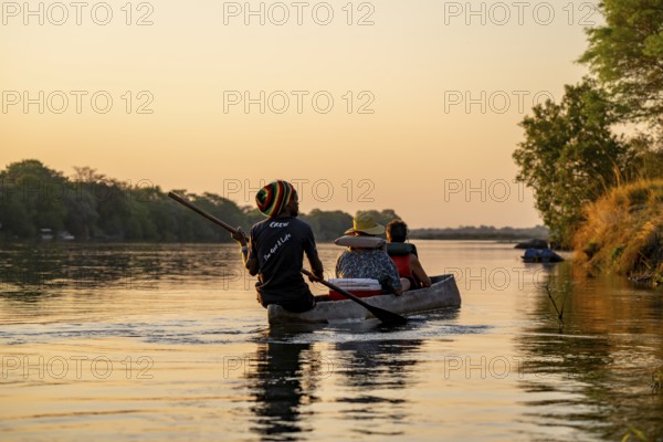 Sunset boat trip, tourists in a Mokoro, dugout boat on the Okavango River, Caprivi Strip, Namibia