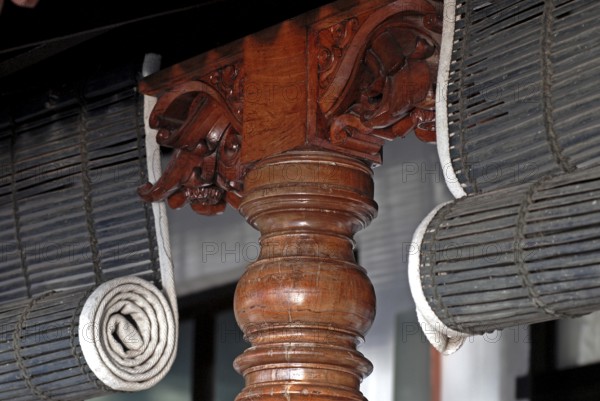 Close-up view of rolled bamboo blinds and artfully turned wooden post, Heritage Hotel Privacy,
