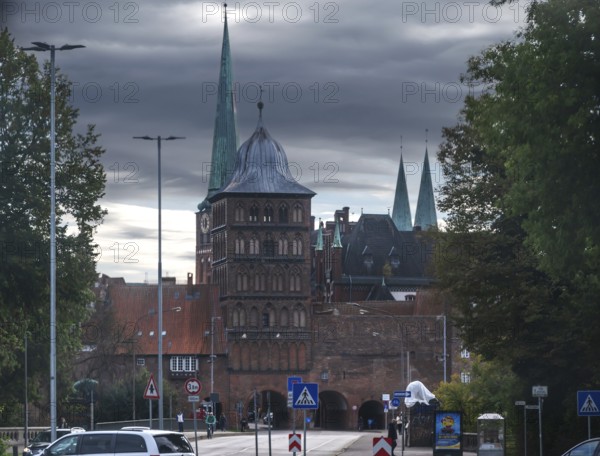 Burgtor, tower of the historic Castel Gate in brick architecture, church towers in the back,