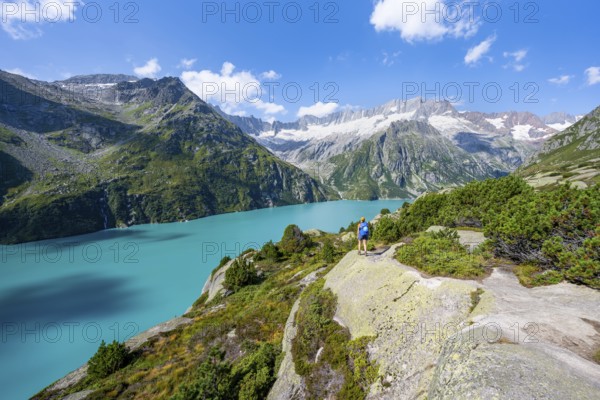 Female mountaineer in front of picturesque mountain landscape, turquoise-blue mountain lake