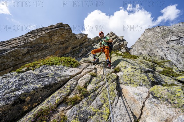 Mountaineers on the secure via ferrata Crocodile Mountain Lake at Bergseeschijen-Vorbau,