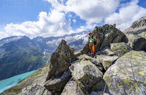 Mountaineers between boulders on the secured via ferrata Crocodile Mountain Lake at