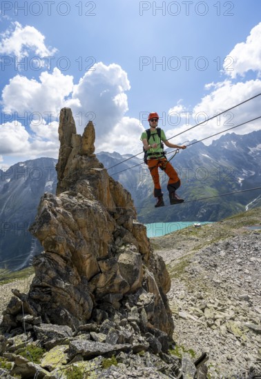 Crocodile rock formation, mountaineer on rope bridge in the Crocodile Mountain Lake via ferrata on
