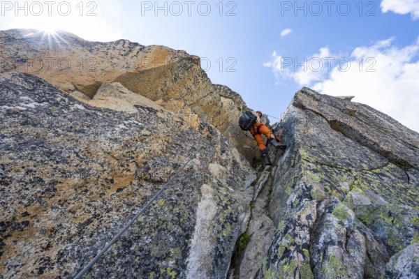 Mountaineers on steep rock face in the secured via ferrata Crocodile Mountain Lake at