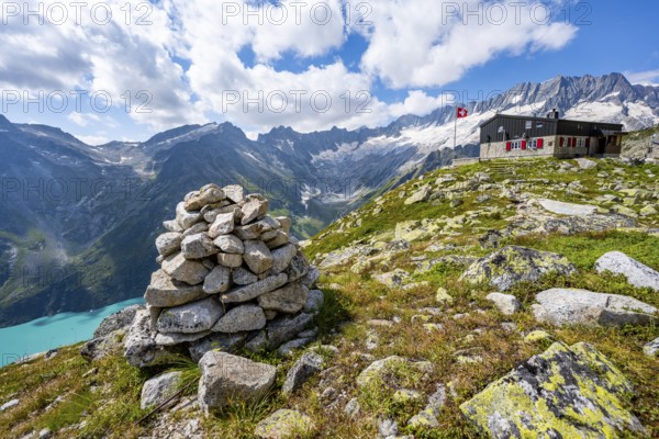Mountain hut BergseehÃ¼tte with Swiss flag in picturesque mountain landscape, view of Damma Glacier