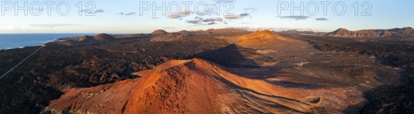 Picturesque volcanic landscape in evening light, red volcano MontaÃ±a Bermeja between lava fields,