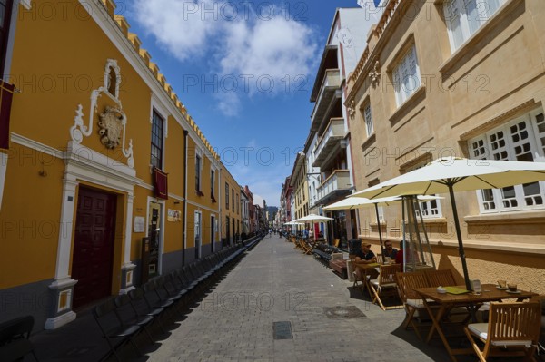 Bustling old town street with cafés and yellow buildings, UNESCO World Heritage Old Town of San