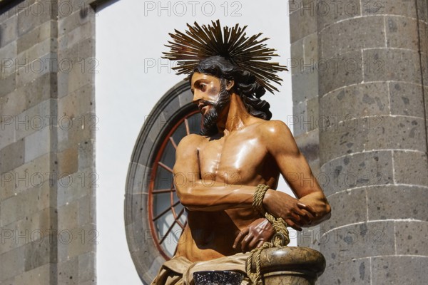 Good Friday procession, Christ statue in front of a stone building in sunlight, UNESCO World