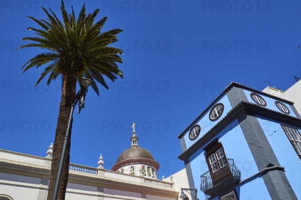Palm tree and classic building against deep blue sky, UNESCO World Heritage Old Town of San