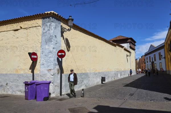 Street scene with man, signs and historic buildings under clear sky, UNESCO World Heritage Old Town