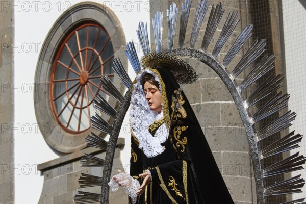 Good Friday procession, statue of Saint Mary in magnificent clothing against a church background,