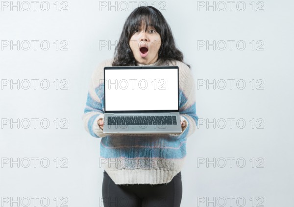 Portrait of beautiful asian girl showing laptop screen isolated. Young Asian woman displaying a