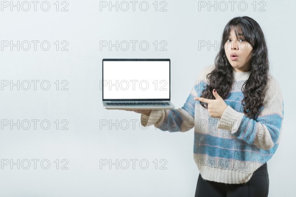 Surprised Young Asian woman displaying a promotion on laptop screen. Portrait of beautiful asian
