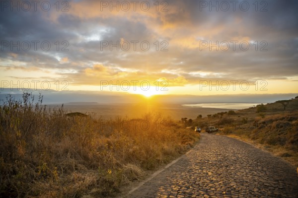 Road leading into Ngorongoro Crater, at sunrise, atmospheric morning light, view of Ngorongoro