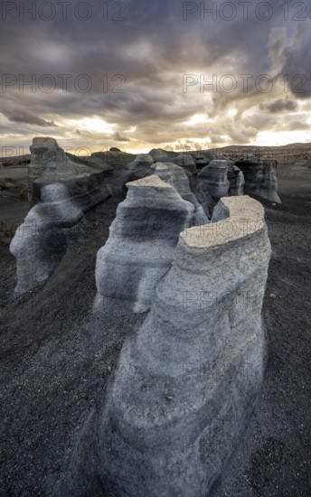 Eroded rock formations, volcanic landscape with dramatic cloudy sky at sunset, Ciudad Estratificada