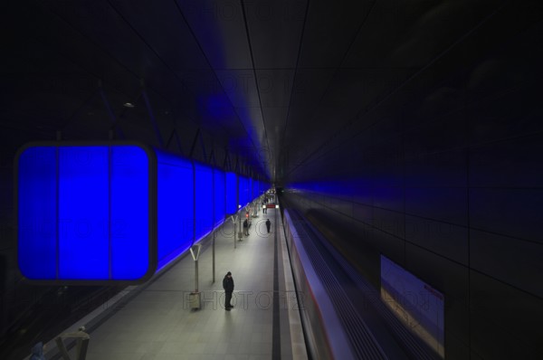 HafenCity University subway station, illuminated in color, blue, travelers, platform, stop, train