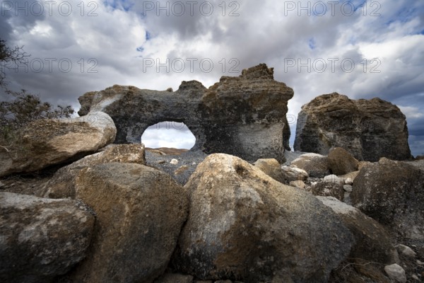 Eroded rock formations with rock tunnels, volcanic landscape with dramatic cloudy skies, Ciudad