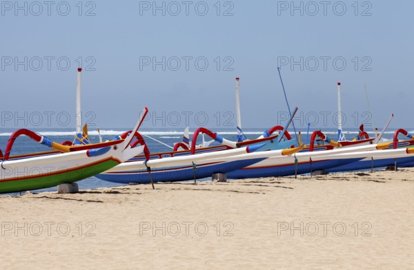 Colourfully painted outrigger fishing boats, (Junkung), on Sanur beach, Bali, Indonesia