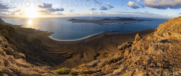 View of steep cliffs to sea and the island of La Graciosa, Mirador del Porrito viewpoint at sunset,
