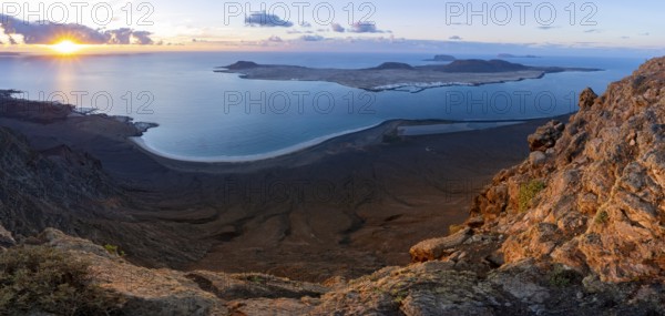 View of steep cliffs to sea and the island of La Graciosa with sun stars, Mirador del Porrito