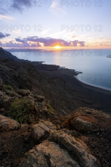 View from steep cliffs to sea and coast with sun stars, Mirador del Porrito viewpoint at sunset,