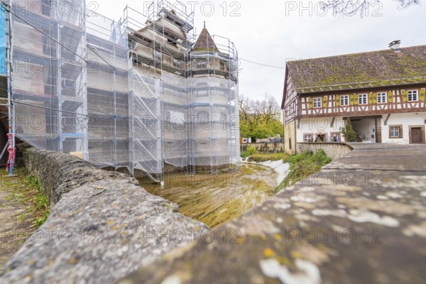 Scaffolded building, adjacent to a half-timbered house in a historic village, Wasserschloss Glatt,