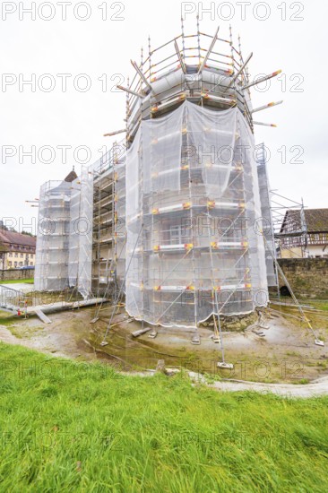 Armored building in rural area with tarpaulins, surrounded by autumn vegetation, Wasserschloss