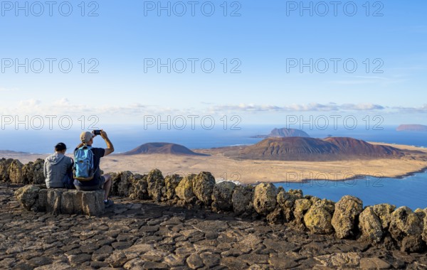 Tourists on a bench on the viewing platform at the Mirador del RÃ­o viewpoint, in the evening