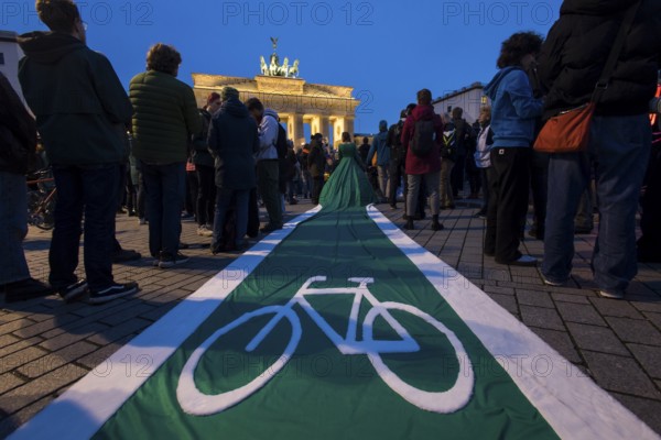 Athena Macke (costume designer) wears a dress with a long train in the shape of a bike path (bike