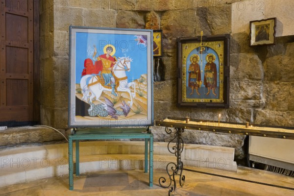Two icons on a metal stand in a traditional church room with stone walls, Bagrati Cathedral, Church