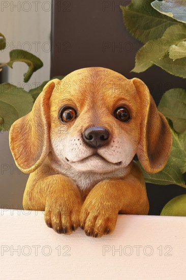 Ceramic dog looking intently in a garden, Wilnsdorf, North Rhine-Westphalia, Germany