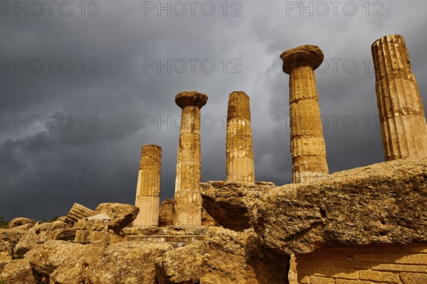 Temple of Heracles, Five ancient columns against dark, looming clouds, Valley of the Temples, Valle