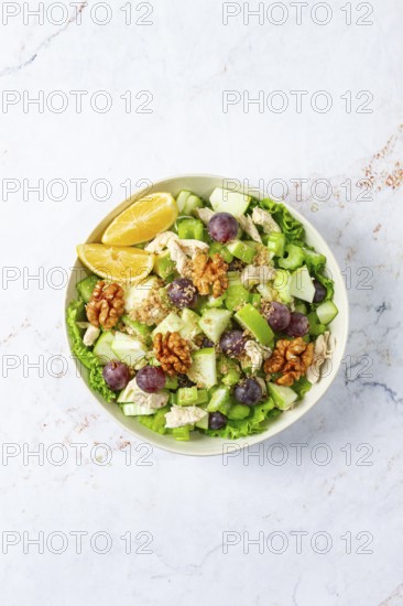 Fresh Waldorf salad, celery stalk with chicken, apple and walnuts, grapes, herbs, homemade, without