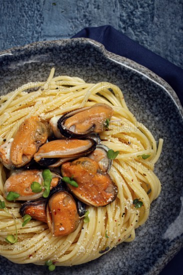 Spaghetti with mussels, without shell, pasta with peeled mussels, in carbonara sauce, micro-greens,