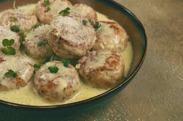 Chicken meatballs, in cream sauce, garnished with parmesan cheese, and microgreens, homemade, no