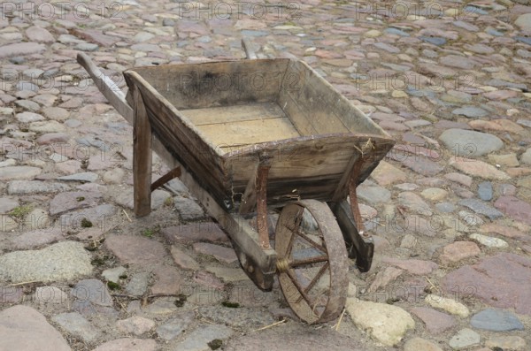 Old-fashioned wheelbarrow on paving stones in Den gamle by, The old village, open air museum in