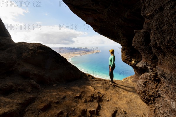 Tourist in the Cueva de las Cabras cave, young woman enjoying the view from the Risco de Famara