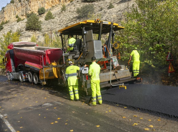 Asphalt road construction team of workers resurfacing tarmac in rural area, near Albarracin, Teruel