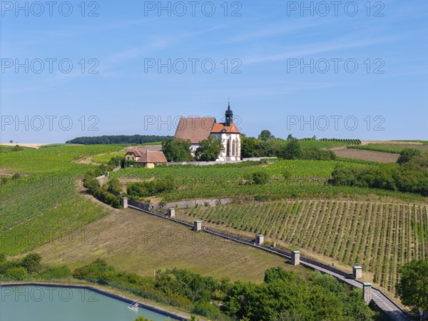 Pilgrimage church Maria im Weingarten, in a hilly, green landscape with blue sky, aerial view, near