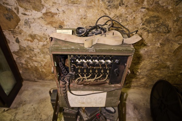 Old telephone in a wooden box with cables, in historical surroundings, war museum, military museum,
