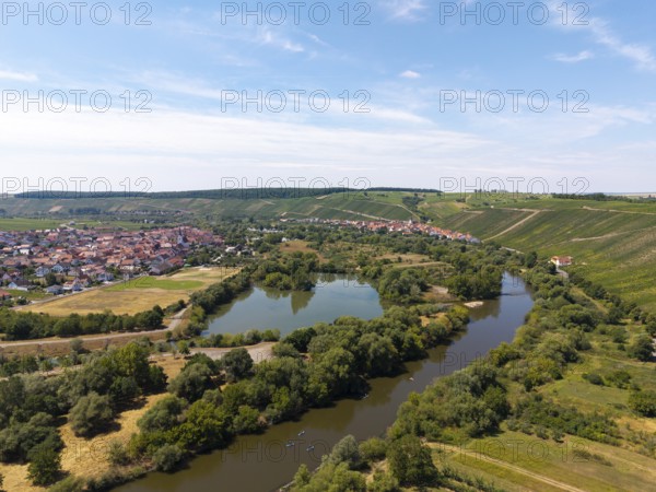 Wide river meandering through a green landscape with a village on the banks, Nordheim am Main,