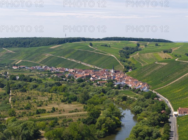 Small village surrounded by green hills and farmland, flanked by a river, Escherndorf near Volkach,